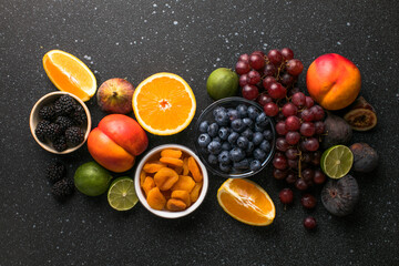 Assortment of fresh exotic fruits and berries on concrete table, flat lay