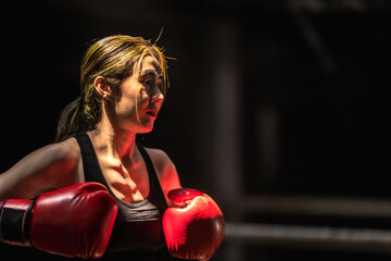Close up Muay Thai boxer woman with boxing gloves, copy space