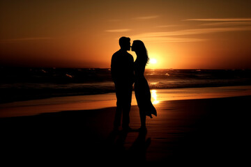 Silhouette of a couple embracing on a beach at sunset