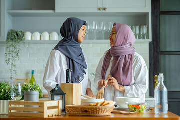 Cute Girl And Her Muslim Mom In Hijab Preparing Pastry For Cookies In Kitchen, Baking Together At Home. Islamic Lady With Daughter Enjoying Doing Homemade Pastry