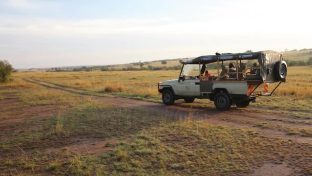 Safari Vehicle Traveling On Kenya Road - Wide, following shot