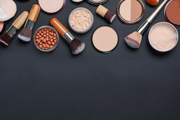 Different face powders and makeup brushes on black background, flat lay. Space for text