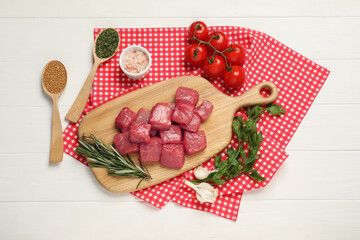 Raw beef meat and different ingredients for cooking delicious goulash on white wooden table, flat...