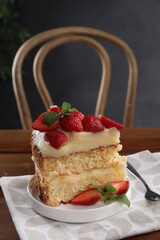 Piece of tasty cake with fresh strawberries and mint on wooden table