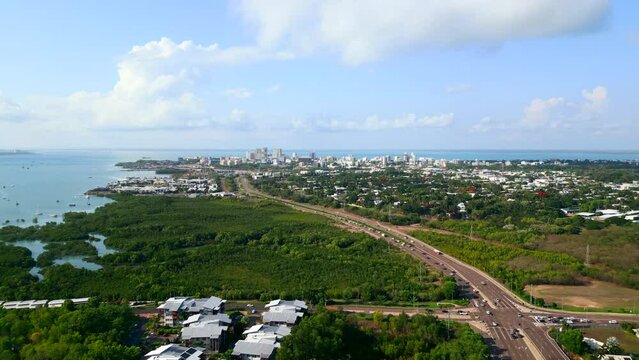 Areal panorama following a freeway into a coastline city. Highway leading into seaside cityscape of Darwin City NT