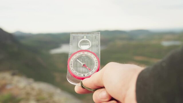 Man Holding A Waterproof Compass With Liquid-filled Protractor. - close up shot