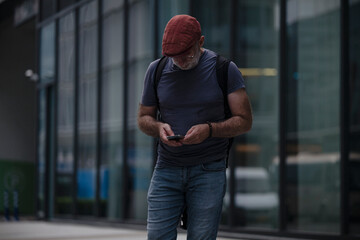 Adult man looking at mobile phone on street