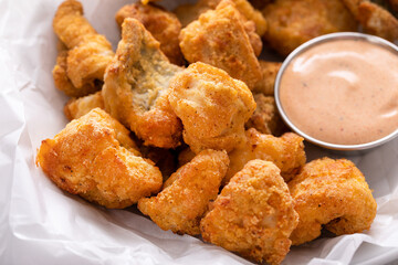 Catfish nuggets in a bowl with dipping sauce