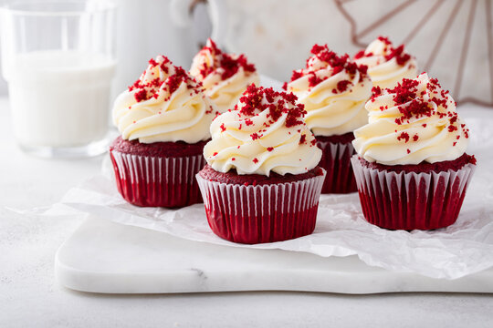 Red velvet cupcakes with cream cheese frosting on a cake stand