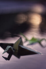 Origami bird in water at sunset