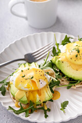 English muffins with arugula, avocado and poached eggs, healthy eggs benedict