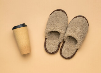 Beige slippers and a glass of coffee on a beige background.