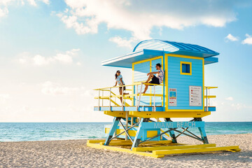 Miami South Beach Florida US, a couple by a lifeguard hut during Sunrise Miami Beach, men and woman...