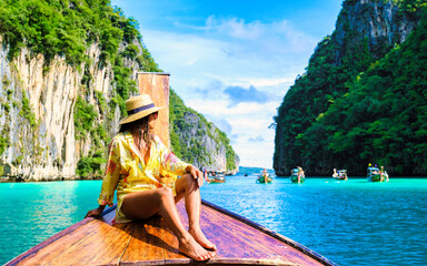 Asian women in front of a longtail boat at Kho Phi Phi Thailand, women in front of a boat at Pileh...
