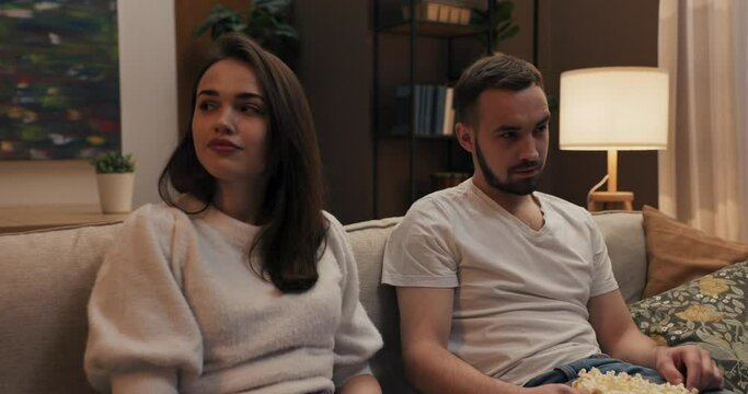 Two roommates sit on couch watching new series on Netflix. watch episode after episode, playfully predict debate their favorite characters.