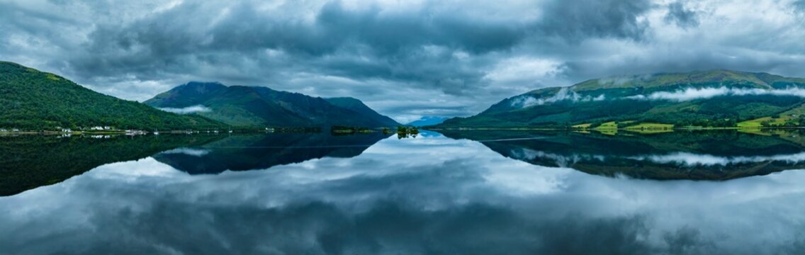 Aerial panorama, morning atmosphere with water reflection over the freshwater loch Loch Leven, Glen Coe Village, Highlands, Scotland, Great Britain