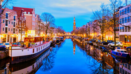 Amsterdam Netherlands canals with Christmas lights during a December evening, canal historical center of Amsterdam at night with reflection in the water - obrazy, fototapety, plakaty