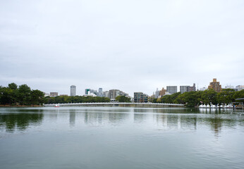 Fototapeta na wymiar River atmosphere of Ohori Park with bridge and city in the background, Fukuoka, Japan