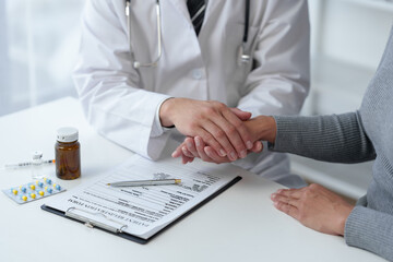Medical service worker or doctor, pharmacist holding hands reassuring a female medical patient at a...