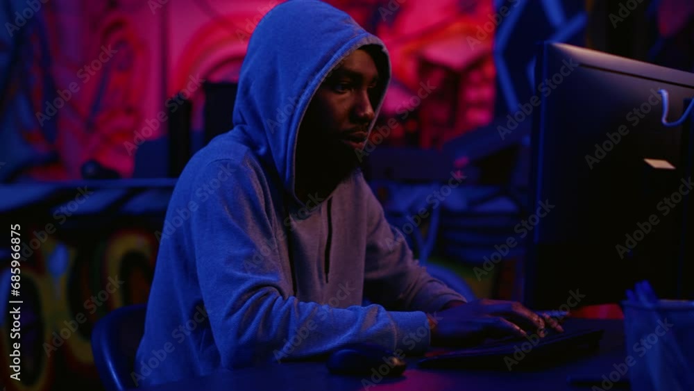 Poster hacker in secret dark room writing lines of code on computer, developing virus that get past securit