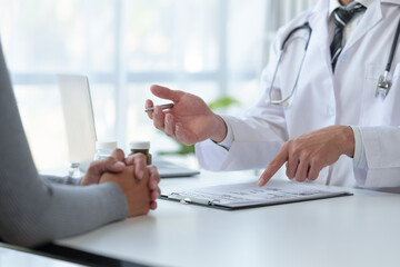 Medical service worker or doctor, pharmacist talking about medical test results at table in clinic Giving advice on how to take medicine to female patients, explaining prescriptions. Health care.