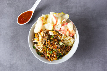 Bubur ayam or Chicken Porridge, Indonesian traditional food consist of white rice porridge, shredded chicken, fried soybean, crackers, leek.