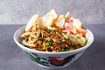 Bubur ayam or Chicken Porridge, Indonesian traditional food consist of white rice porridge, shredded chicken, fried soybean, crackers, leek.