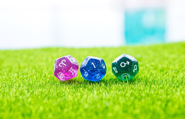 Astrological dices fortune telling divination dice on green grass with space on blurred background,...