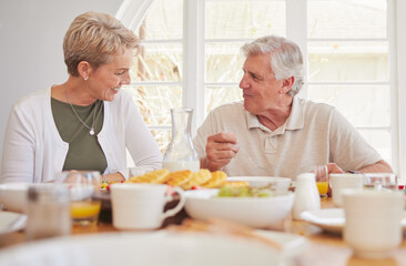 Fototapeta na wymiar Breakfast, talking and lunch with senior couple, eating and happy together in a home. Love, support and care on a dining room with a smile and food with bonding in the morning with fruit in house