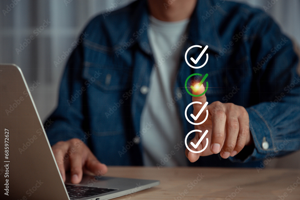 Poster businessman using laptop doing online checklist survey, check marks on checklist and filling online 