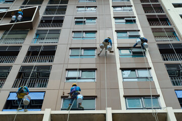 A painter is abseiling from a high-rise building. A painter using sling cables and safety tools. 