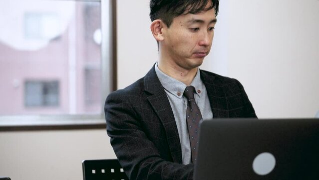 ノートパソコンを使って資料を作成する男性ビジネスマン