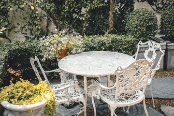 Classic table set in the garden. Vintage luxury victorian style mable stone table chair at outdoor...