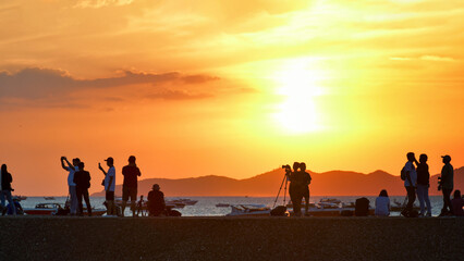 Fototapeta premium People enjoyed capturing sunset at the beach.
