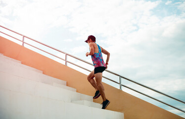Runner practicing climbing stairs To go compete in a marathon on a summer evening