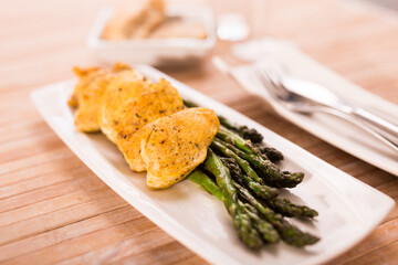 Chicken nuggets with green asparagus on plate