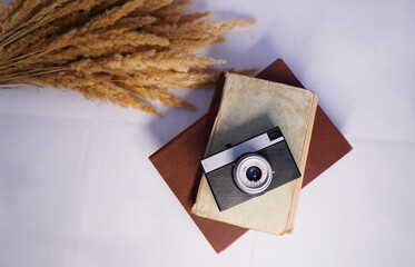 retro camera on a white background, book and dried flowers