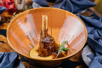 Braised Lamb Shanks or mutton shank served in dish isolated on table top view of meat main course...