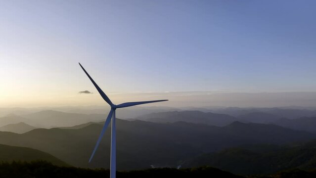 Wind power generator on the mountain against the background of the sunrise. 풍력 발전기, 풍력 터빈.