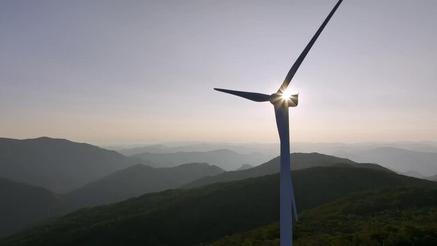 Wind power generator on the mountain against the background of the sunrise. 풍력 발전기, 풍력 터빈, 아침.