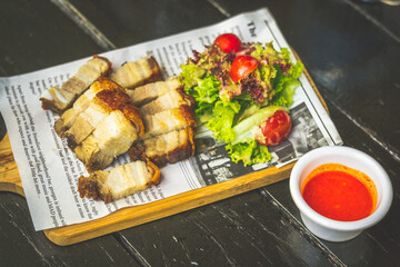 Crispy pork belly served with housemade spicy dip and served on a wooden platter