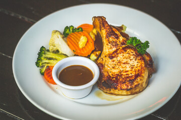 Succulent 300gm bone in pork chop served with mashed potatoes, buttered vegetables and finished with homemade LP sauce