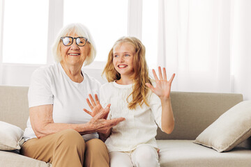 Elderly woman grandmother love girl granddaughter happy sofa home couch old child family