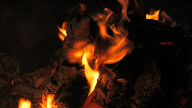 Slow motion video of a log fire with tree trunks closeup detail fire and flames. Flames and burning sparks close-up,fire patterns