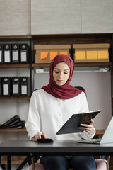 Obraz premium Happy muslim woman working at desk in office, 