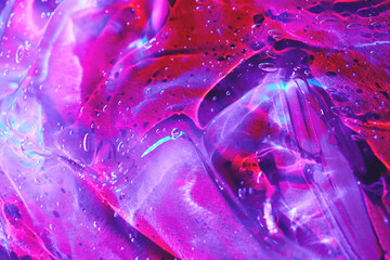 Full frame neon purple, magenta pink, red, blue holographic transparent cosmetic gel serum background texture, smudge slime with drips and bubbles. Abstract surreal psychedelic jelly backdrop.