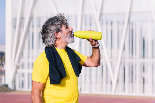 senior sports man drinking water during training, concept of healthy and active lifestyle in middle age, copy space for text