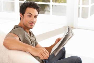 Man, portrait and smile with newspaper on sofa for relax, morning break and information in living room. Person, face and happy for article, story and news on couch of apartment for reading or peace