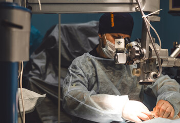 Focused veterinary ophthalmologist performs major surgery on an animal's eye in a veterinary...