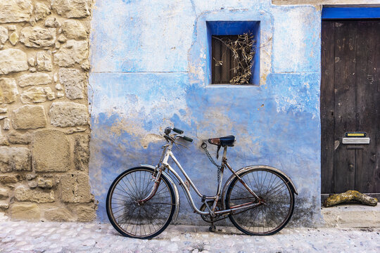 old bicycle in front of a blue wall